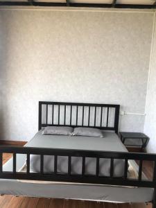 1 dormitorio con 1 cama negra y 2 almohadas en Doi Hoa Do Homestay, en Bao Loc