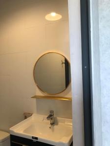 y baño con lavabo y espejo. en Doi Hoa Do Homestay, en Bao Loc