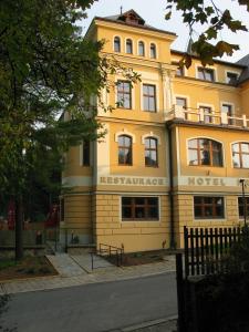 um edifício amarelo no lado de uma rua em Hotel Hron em Náchod