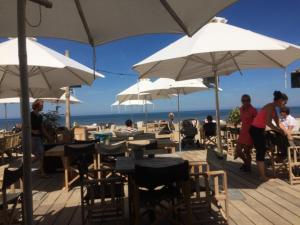 a group of people sitting at tables under umbrellas on the beach at Bed and Breakfast in Zilk