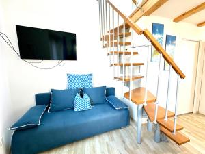 a living room with a blue couch and a tv at Old Piran Starfish in Piran