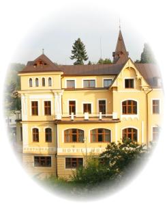 a large yellow building with a roof at Hotel Hron in Náchod