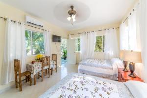 a bedroom with two beds and a table and chairs at Mandala Villas Hotel & "Sarita's Mexican Restaurant in Chiquila