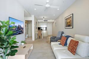 uma sala de estar com um sofá branco e uma mesa em Cosy 1-Bed with River Views Pool Gym & BBQ em Brisbane