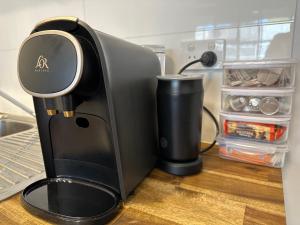 a black coffee maker sitting on top of a counter at One-Bedroom Apartment on Summer in Orange