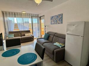 ein Wohnzimmer mit einem Sofa und einem Kühlschrank in der Unterkunft Appartement Argelès-sur-Mer, 2 pièces, 4 personnes - FR-1-225-807 in Argelès-sur-Mer