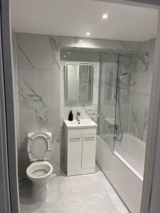 a white bathroom with a toilet and a shower at Modern 1 Bedroom Apartment Town Centre Camberley in Camberley