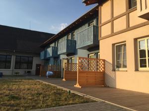 un edificio con una terraza de madera al lado de un patio en Nidos stiegė, en Nida