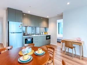 a kitchen and dining room with a wooden table at Pride CBD Skyline View 2B2B Apartment LV32 in Melbourne