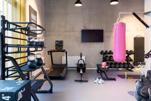 a gym with a bunch of equipment in a room at Moxy Outletcity Metzingen in Metzingen