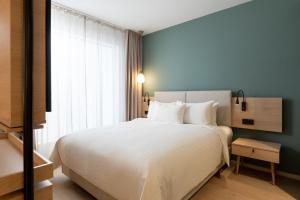Un dormitorio con una gran cama blanca y una ventana en Element Wroclaw, en Wroclaw