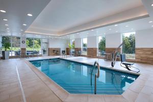 a swimming pool in a hotel lobby with a large window at TownePlace Suites by Marriott Edgewood Aberdeen in Belcamp