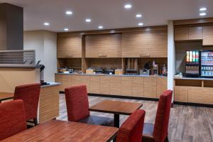 a restaurant with tables and chairs and a kitchen at TownePlace Suites by Marriott Edgewood Aberdeen in Belcamp