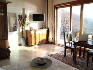 a living room with a table and a view of a balcony at Falco Cascina Borchina in Musignano