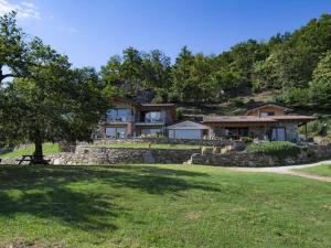 una casa grande en una colina con un campo de hierba en Falco Cascina Borchina en Musignano