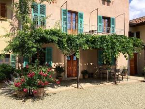 ein Haus mit einer Pergola und Blumen davor in der Unterkunft Holiday home Casa Nanda in Mombaruzzo