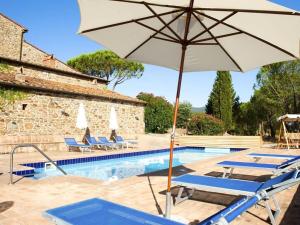 una piscina con sombrilla y tumbonas y una piscina en Holiday apartment Casa Serena, en Caldana