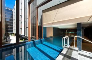 una piscina en medio de un edificio en Center 2-Bed with Gym, Sauna, Indoor Pool & Views, en Canberra