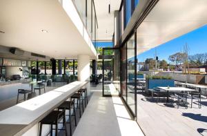 - Vistas a un restaurante con mesas y sillas en Center 2-Bed with Gym, Sauna, Indoor Pool & Views, en Canberra