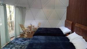 巴耶德布拉沃的住宿－Glamping Don Delfis，一间卧室配有两张床和一张桌椅