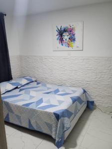 a bed in a room with a picture on the wall at Hostel Campoamor in Medellín