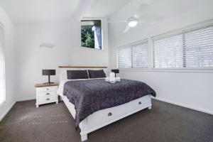a white bedroom with a bed and a window at The Mediterranean - Escape to Tranquility Save Up to 350 this May and June in Falls Creek