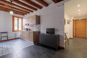 eine Küche mit weißen Wänden, Holzschränken und einem Tisch in der Unterkunft Rialto Bridge! Comodo appartamento in centro - 2 in Venedig