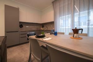 a kitchen with a counter and a kitchen island with chairs at Casa Vacanza Rimini in Rimini