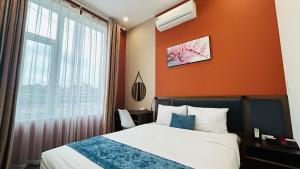 ein Hotelzimmer mit einem Bett und einem Fenster in der Unterkunft Mango Hotel - Ha Noi Railway station in Hanoi