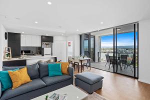 a living room with a couch and a kitchen at Peninsular Gold Coast in Gold Coast
