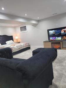 uma sala de estar com um sofá e uma televisão de ecrã plano em Langston Beautiful Home em Brampton