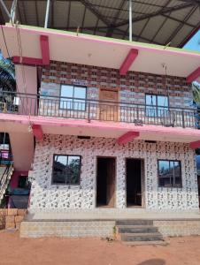 a brick building with a balcony on top of it at D'Souza Rooms in Māvalli