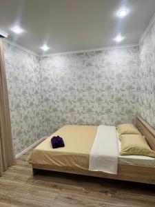 Un dormitorio con una cama con un sombrero púrpura. en Квартира посуточно, en Kokshetau