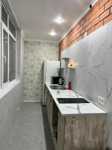 uma cozinha com um lavatório e um frigorífico em Квартира посуточно em Kokshetau