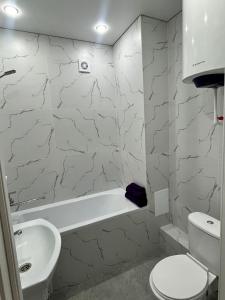 uma casa de banho com um lavatório, uma banheira e um WC. em Квартира посуточно em Kokshetau