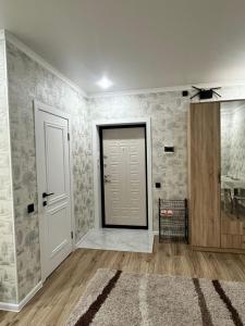 een lege kamer met een deur en een tapijt bij Квартира посуточно in Köksetaw