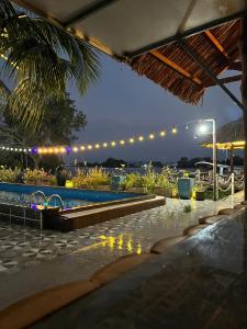 a swimming pool at night with lights in a resort at NAI Homestay in Ben Tre