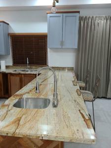 a kitchen with a wooden counter top with a sink at Beachscape At Black River Zermatt in Black River