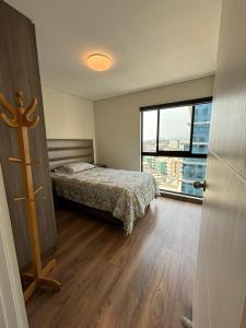 een slaapkamer met een bed en een groot raam bij LA POSADA de GUILLE - LUXURY APARTS NEXT TO USA EMBASSY in Lima