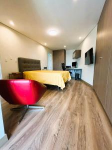 Habitación con cama y silla roja. en LA POSADA de GUILLE - LUXURY APARTS NEXT TO USA EMBASSY en Lima