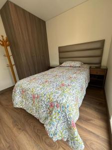 een slaapkamer met een bed met een kleurrijk dekbed bij LA POSADA de GUILLE - LUXURY APARTS NEXT TO USA EMBASSY in Lima