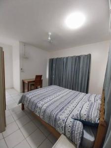 a bedroom with a bed with a curtain and a table at Harbour View House at Point Cruz, Honiara in Honiara