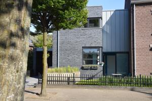 une maison en briques avec une fenêtre et une clôture dans l'établissement Het blauwe huis, à Reuver