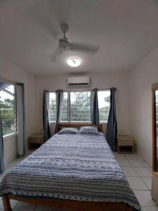 a bedroom with a bed in a room with windows at Harbour View House at Point Cruz, Honiara in Honiara