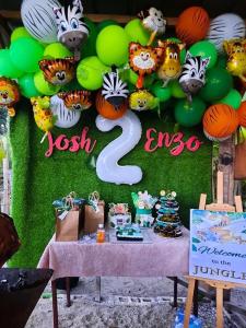 a birthday party with a table with green and green balloons at Destiny Rainbow Beach Resort in Siquijor