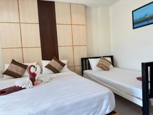 Una habitación con dos camas con un cisne relleno. en JS Residence Krabi, en Krabi