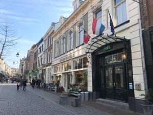 Une rue où les gens marchent devant un magasin dans l'établissement Hotel De Gulden Waagen, à Nimègue