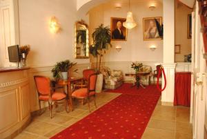 a hallway with a table and chairs and a red rug at Hotel De Gulden Waagen in Nijmegen