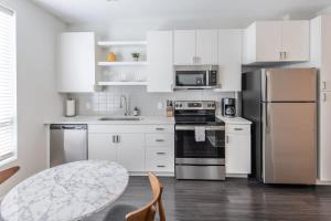 a kitchen with white cabinets and stainless steel appliances at Cozysuites l Gorgeous 1BR in Downtown Cincinnati in Cincinnati