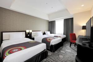 um quarto de hotel com duas camas e uma televisão em The Royal Park Hotel Fukuoka em Fukuoka